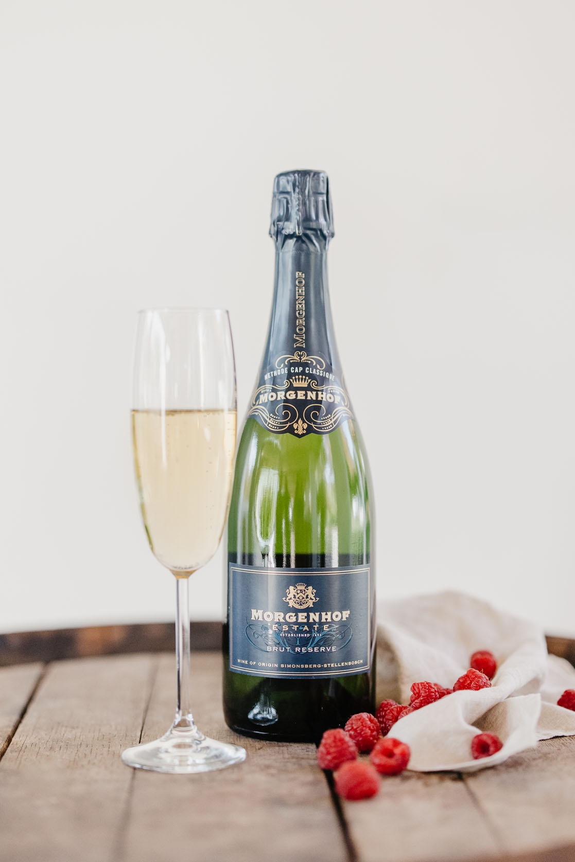Morgenhof Estate Brut Reserve sparkling wine with a filled flute and fresh raspberries